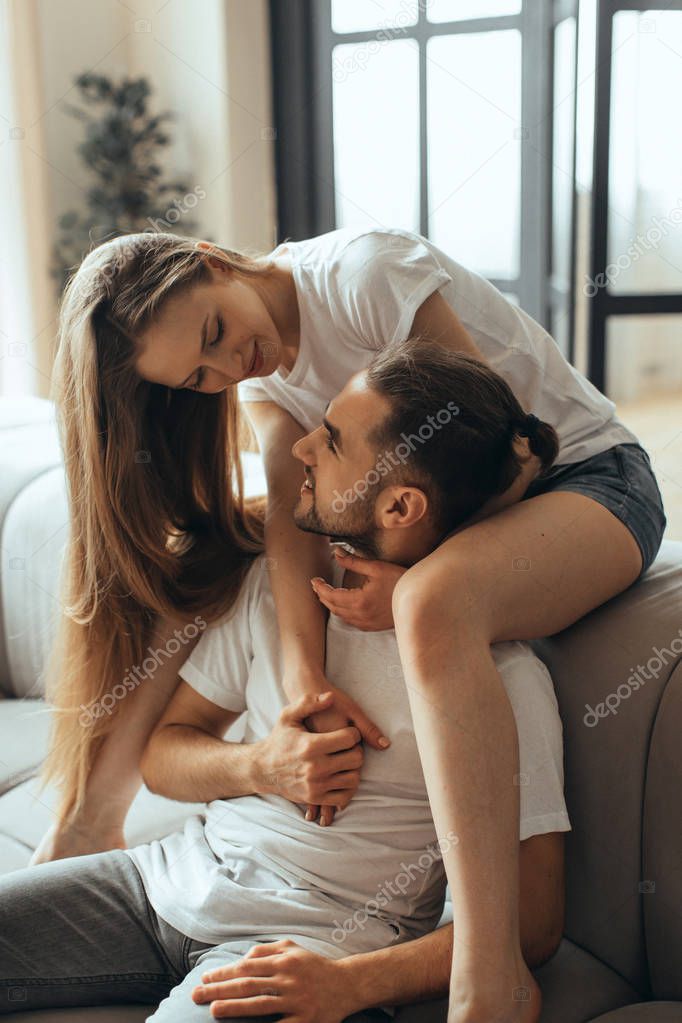 Close-up of young romantic couple is kissing and enjoying the company of each other at home