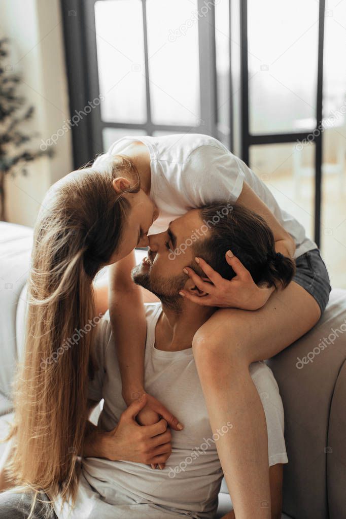 Close-up of young romantic couple is kissing and enjoying the company of each other at home