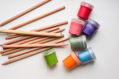 Renkli kalemler ve birkaç farklı boya şişesi, suluboya.
