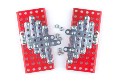 Meccano Yüreği: Bir inşaatçı tarafından inşa edilmiş iki yarının ortak kalbi, iki yarının arasında birkaç vida ve fındık, beyaz arka plan, üst görünüm, merkezi kısma kısa odaklanma