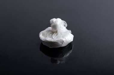 Beyaz toz (eroin, kokain, narkotik) siyah bir arkaplanda plastik bir torba içinde