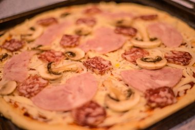 Yanlış yüksek kalorili yemek: sosisli, mantarlı, mozzarella ve baharatlı çiğ olmayan pizza.