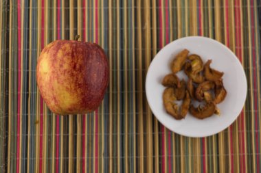 olgun kırmızı elma ve kurutulmuş armut çok renkli bambu bir kasede.
