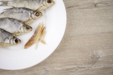 bira aperatifi: beyaz tabakta 4 güneşte kurutulmuş tatlı su balığı - vitamin ve protein kaynağı, soyulmuş et, açık masa, konum