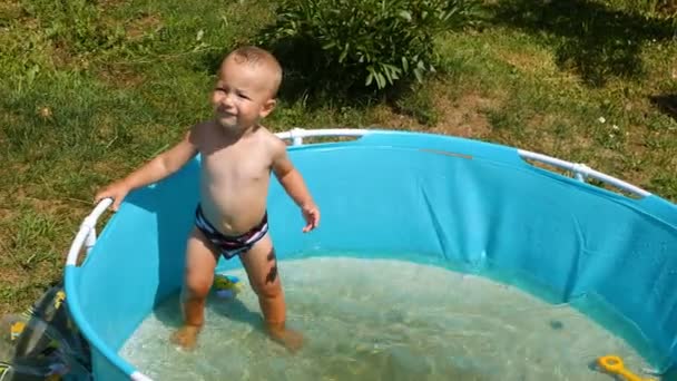 夏の暑い日に人工赤ちゃんプールを浴びて 年を歳の小さな男の子の撮影 — ストック動画