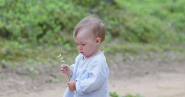Ormandaki kumlu yolda ilk adımlar. Bir yaşındaki küçük kız annesi ve büyükannesiyle ormanda yürüyor.