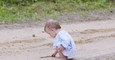 Ormandaki kumlu yolda ilk adımlar. Bir yaşındaki küçük kız annesi ve büyükannesiyle ormanda yürüyor.