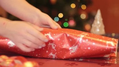 Büyükannesinin Noel ve yeni yıl için torununa hediye paketlediği yavaş çekim. Noel ve yeni yıl tatili için hazırlık kavramı, Noel ağacı geçmişi