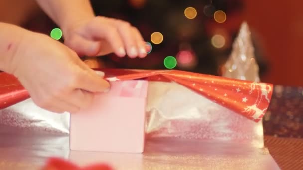 奶奶为孙女包装圣诞礼物和新年礼物的慢镜头 圣诞及新年假期的筹备概念 圣诞树背景 — 图库视频影像