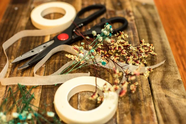 Kurumuş çiçekler ve el işi aletleri.