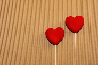 Doğal kahverengi karton yüzeyi iki kırmızı kadife kalp. St. Valentine's gün tebrik kartpostalı. Lover's gün. Aşk arka plan.