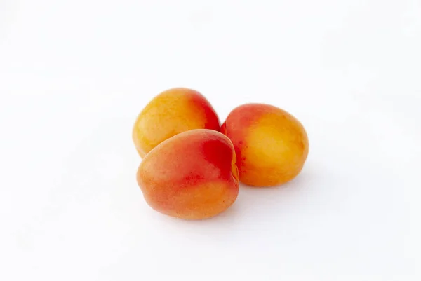 Färsk ekologisk aprikos på vit botten. tre aprikoser. — Stockfoto