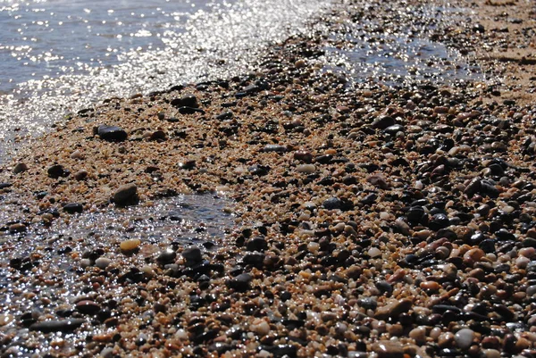 Волны и прозрачная вода на песке на пляже. Текстура. Пена для воды. Солнечный день — стоковое фото