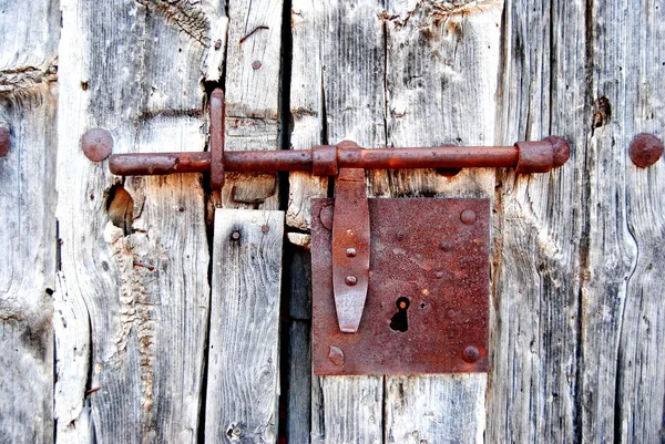 Porta velha com parafuso enferrujado, fechadura. enferrujado, oxidado. Dobradiça. Madeira velha . — Fotografia de Stock