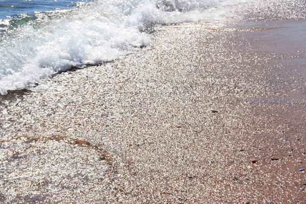 Κύματα και διαφανές νερό στην άμμο στην παραλία. Υφή. αφρός νερού. Ηλιόλουστη μέρα — Φωτογραφία Αρχείου