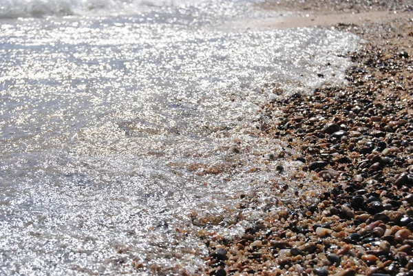 Волны и прозрачная вода на песке на пляже. Текстура. Пена для воды. Солнечный день — стоковое фото