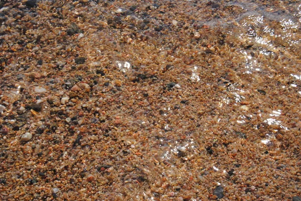 Ondas e água transparente na areia da praia. Textura. Espuma de água. Dia ensolarado — Fotografia de Stock