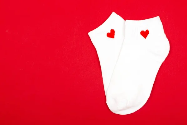 Paar witte sokken op rode achtergrond — Stockfoto