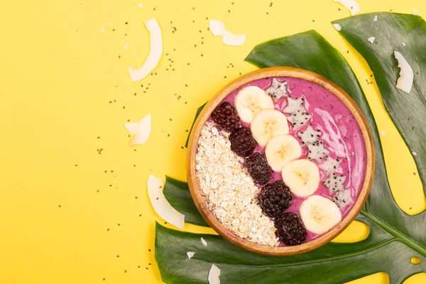 Smoothie bowl on yellow background