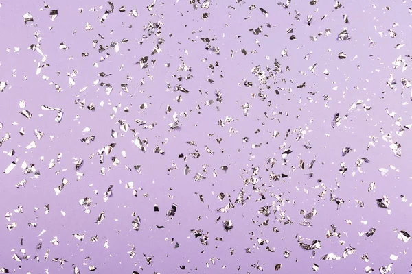 Zilver folie confetti op paarse achtergrond. — Stockfoto