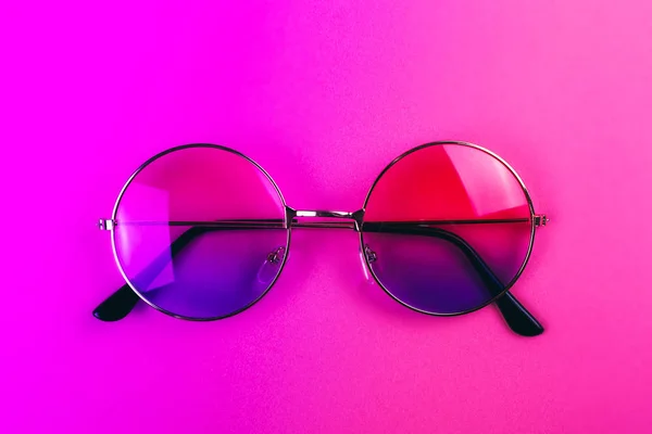 Okrągłe okulary przeciwsłoneczne na świetle Neon bichromii. — Zdjęcie stockowe