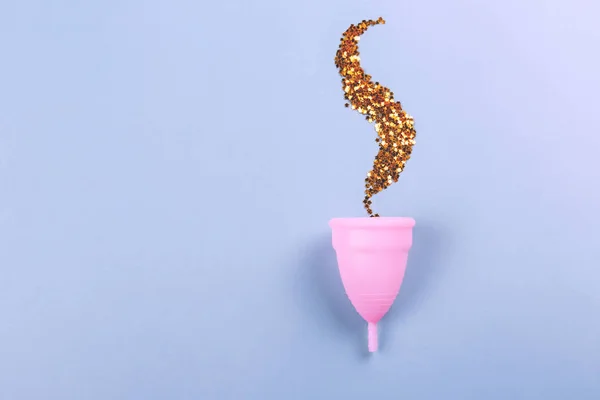 Розовая менструальная чашка на синем фоне . — стоковое фото