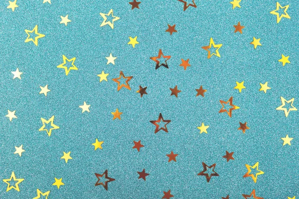 Fondo festivo. Estrellas de confeti doradas sobre papel brillo azul . —  Fotos de Stock