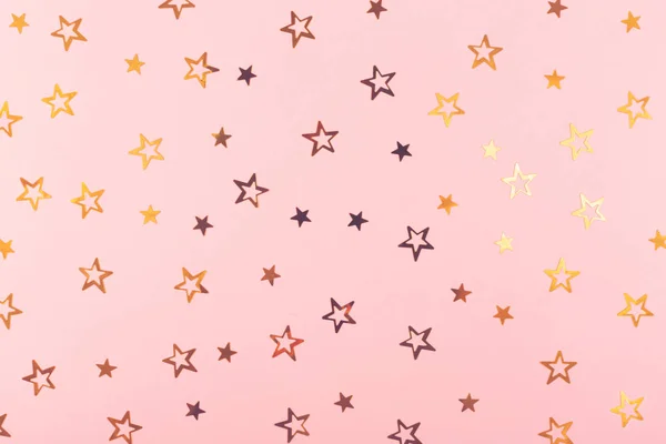 节日背景。粉红色纸上的金色五彩纸星星. — 图库照片