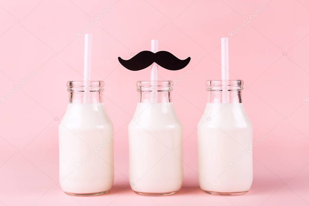 Three bottles of milk of yogurt on pink background.