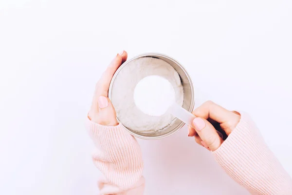 Um frasco com pó de colágeno e colher de colher em mãos de mulher . — Fotografia de Stock