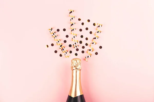 香槟酒瓶和意大利面粉红背景的创意新年作曲. — 图库照片