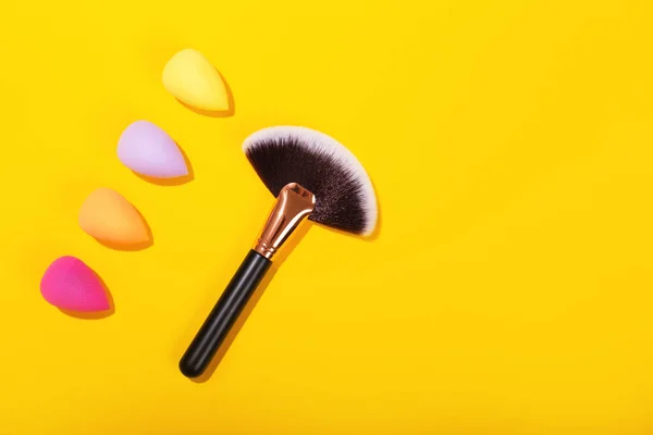 Colorful beauty sponges on bright yellow background. — Stock Photo, Image