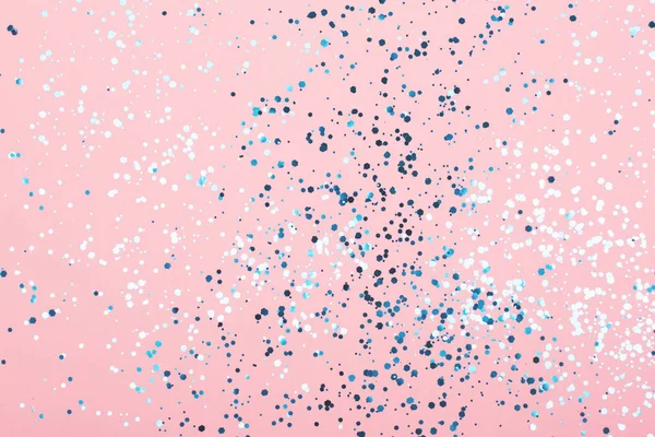 Padající konfety v modré barvě na růžovém pozadí. — Stock fotografie