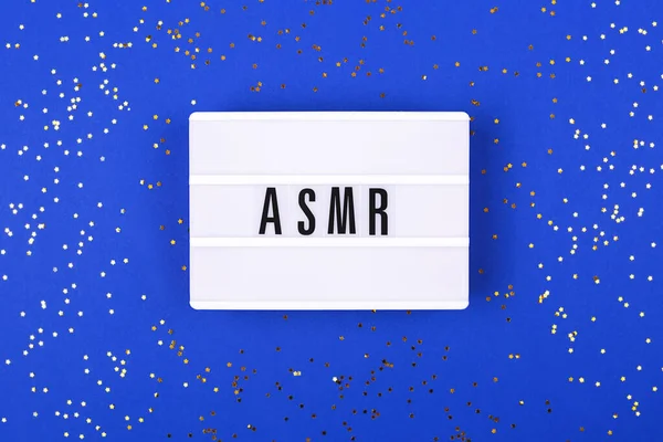 De lamp met letters ASMR op blauwe achtergrond. — Stockfoto