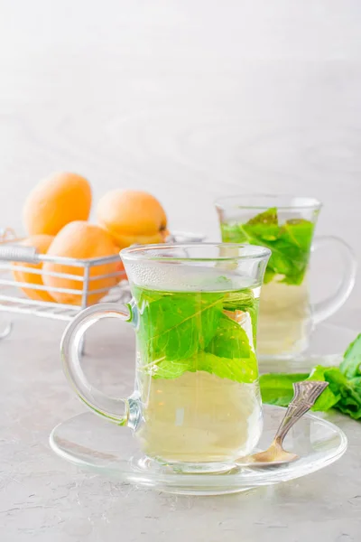 Hot tea with mint leaves in transparent glasses on the table