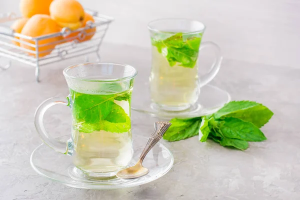 Hot tea with mint leaves in transparent glasses on the table