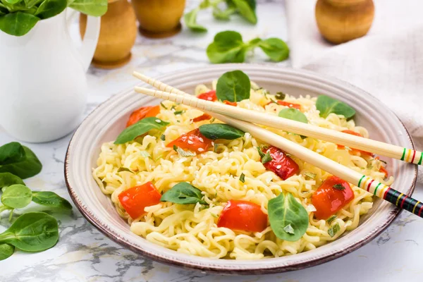 Noodles with pepper, lettuce leaves and sesame seeds in a cerami