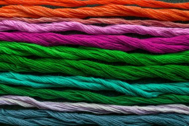 Parlak renkli Nakış iplik iplik. Çok renkli turuncu, pembe, mor, yeşil, Turkuaz, mavi Nakış iplikleri karanlık keçe tuval üzerine skeins. El yapımı nakış dikiş arka plan