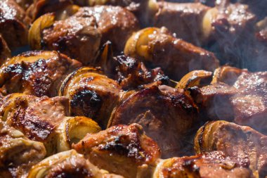 Barbekü kuzu souvlaki şiş tarifi. Kuzu kebaplar. Duman ile açık bir yangın şiş üzerinde Marine edilmiş kuzu eti parçaları kavrulmuş. Yakın çekim. Seçici odak