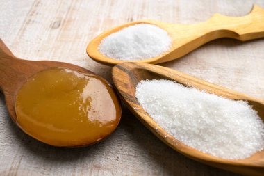 Yapay tatlandırıcı ve şeker yerine tahta kaşıklar içinde. Doğal ve sentetik sugarfree gıda katkı: sorbitol, fruktoz, tatlım, sukraloz, aspartam