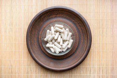 Ashwagandha (Whitania somnifera) sebze bitki kapsül üzerinde kahverengi kil plaka yuvarlak. Ayurveda Adaptogen Hindistan, genel tonik, bitkisel diyet takviyeleri. Sağlıklı yaşam, bağışıklık sistemi