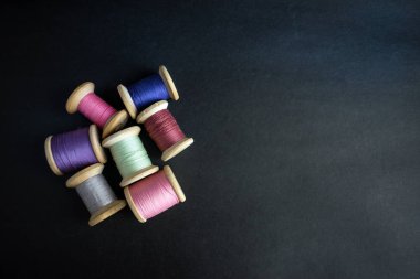 Pastel kümesi iplik dikiş siyah bir arka plan için renk. Bobin retro tarzı iş parçacığı kümesi. Vintage dikiş masada aksesuarları. Çok renkli biriktiricileri izole iş parçacığı
