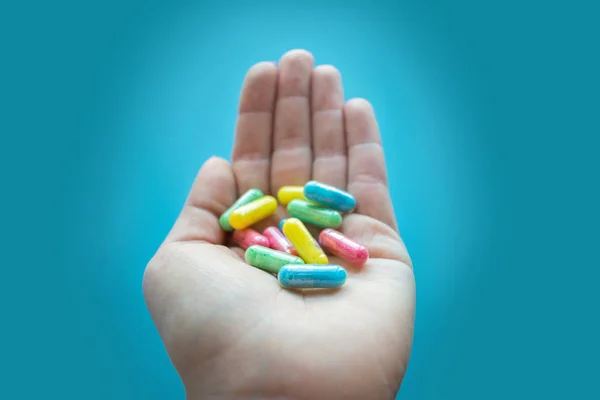 Pastillas Coloridas Medicamentos Mano Femenina Sobre Fondo Azul Diferentes Píldoras — Foto de Stock
