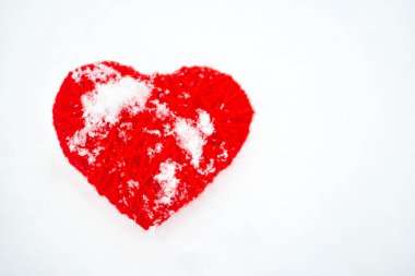 Güzel romantik vintage kırmızı iplik kalp beyaz kar kış arka plan üzerinde. Kalp el yapımı sembolü kar bir arka plana dayanır. Aşk romantik ve Sevgililer günü kavramı.  