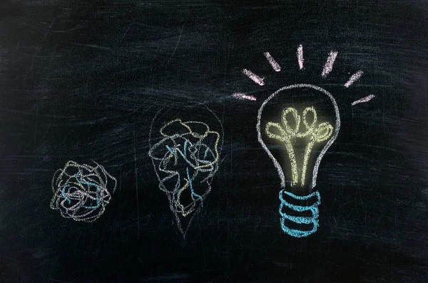 Chalkboard with Chalk Drawing of Hanging Light Bulb. Bright idea on blackboard concept. Way of thinking, the birth of idea. Creative, bright, unusual, interesting idea. Eureka, thought, flash, inspiration.