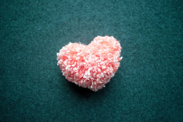 Kabarık pembe iplik kalp gri arka plan hissettim. El yapımı güzel kalp. Aşk, aşk, Sevgililer günü DIY kavramı. Seçici odak