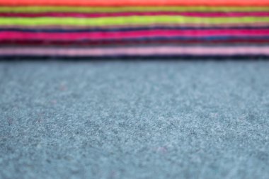 Pile of felt flaps blurred background. Defocus Stack of colorful felt flaps on a gray fabric background. Handmade, creativity, crafts, sewing, needlework background clipart
