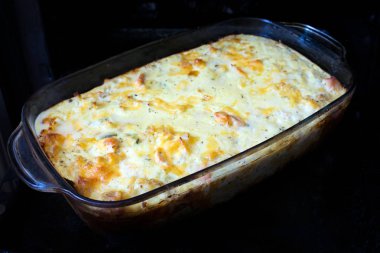 Et, sebze ve peynir fırında ile ev yapımı güveç. Arka planı karanlık fırın tepsisi ve fırın çanak pişirme cam lezzetli graten. Lezzetli peynir kabuk ile açık kiş pasta 