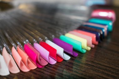 Manikür çivi renk tasarım örnekleri. Koyu ahşap arka plan üzerinde sanat el yapımı örnekleri çivi. Güzellik salonları için tasarım şablonları. Seçici odak. Yakın çekim