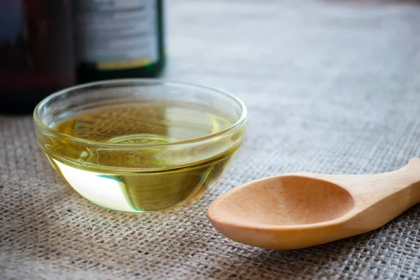 液态椰子在圆形玻璃碗中用木勺和瓶子的油 Mct 油的健康益处 甘油三酯 一种饱和脂肪酸的形式 — 图库照片